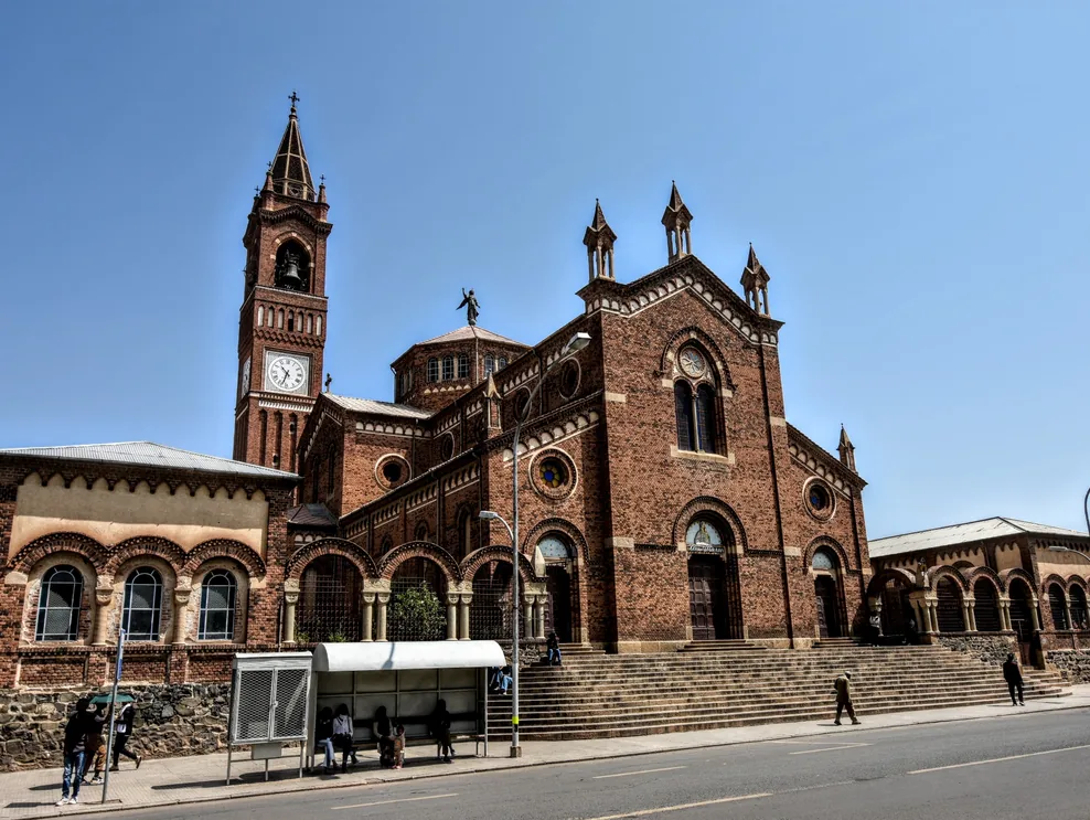 Red-brick cathedral and bell tower on a sunny street in Asmara, Eritrea