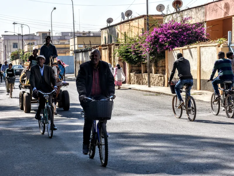 Cyclists riding along a city street in Eritrea